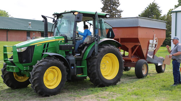 Extension educator assisting youth during the tractor and equipment safety course