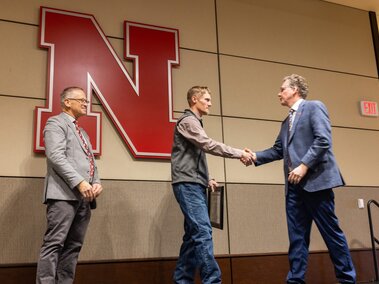 Roger Carpenter accepting an award from Derek McLean at the 2024 staff appreciation luncheon.